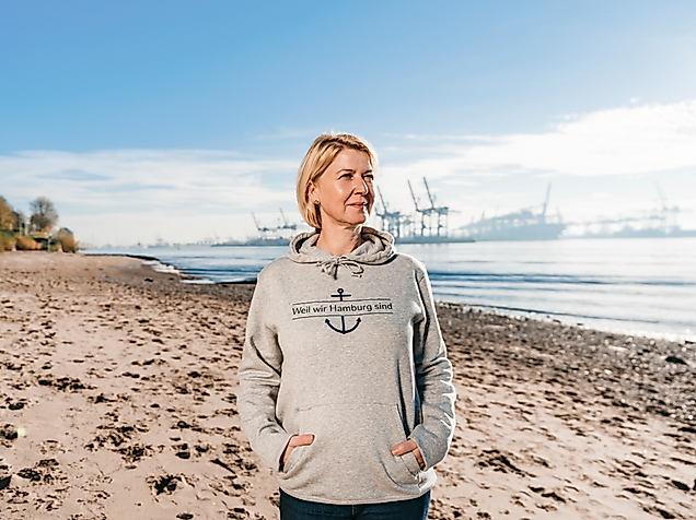 Frau mit Weil Wir Hamburg sind Hoodie am Elbstrand